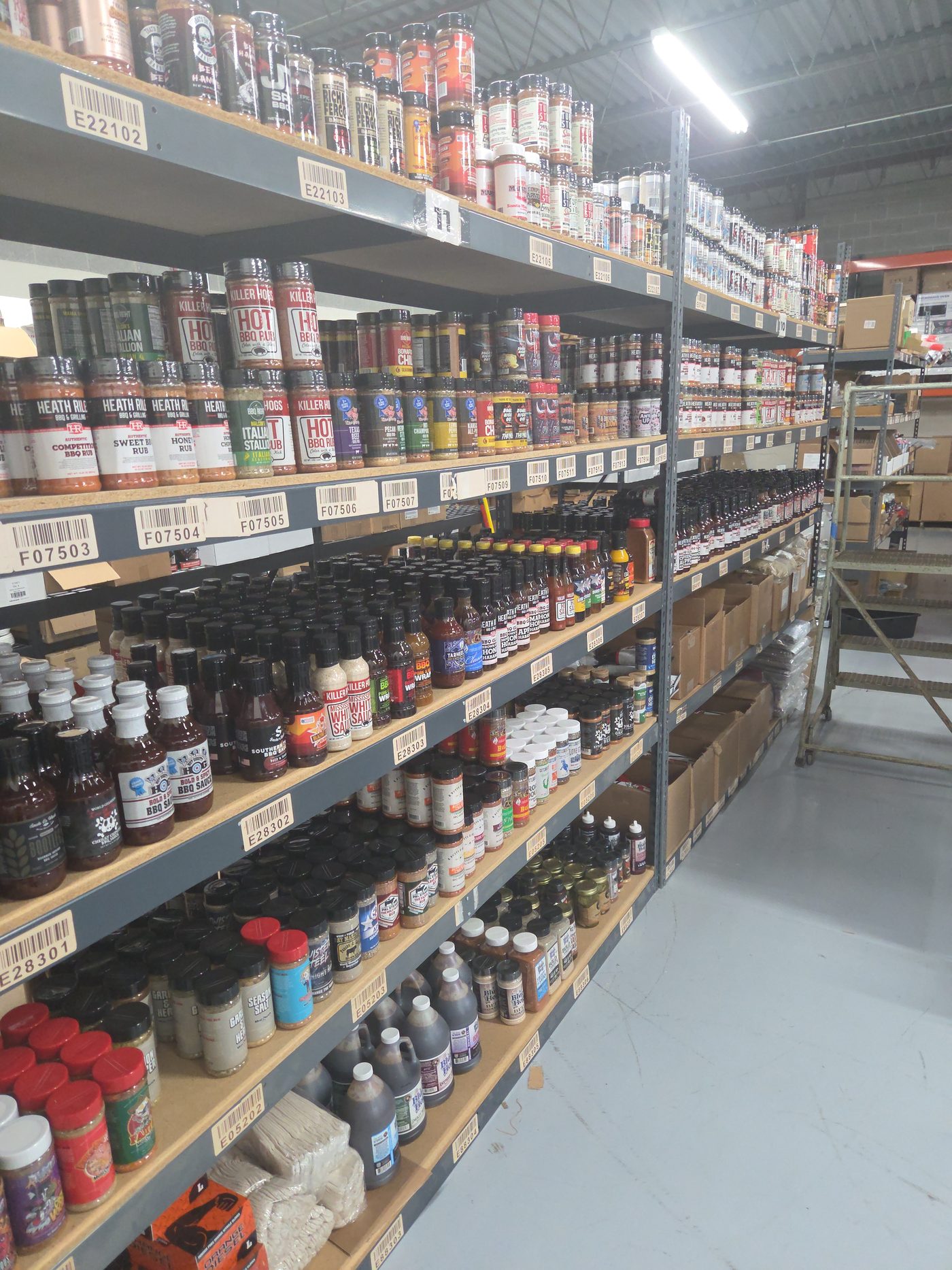 Aisle of organized, barcode-labeled branded product in the Hardway warehouse